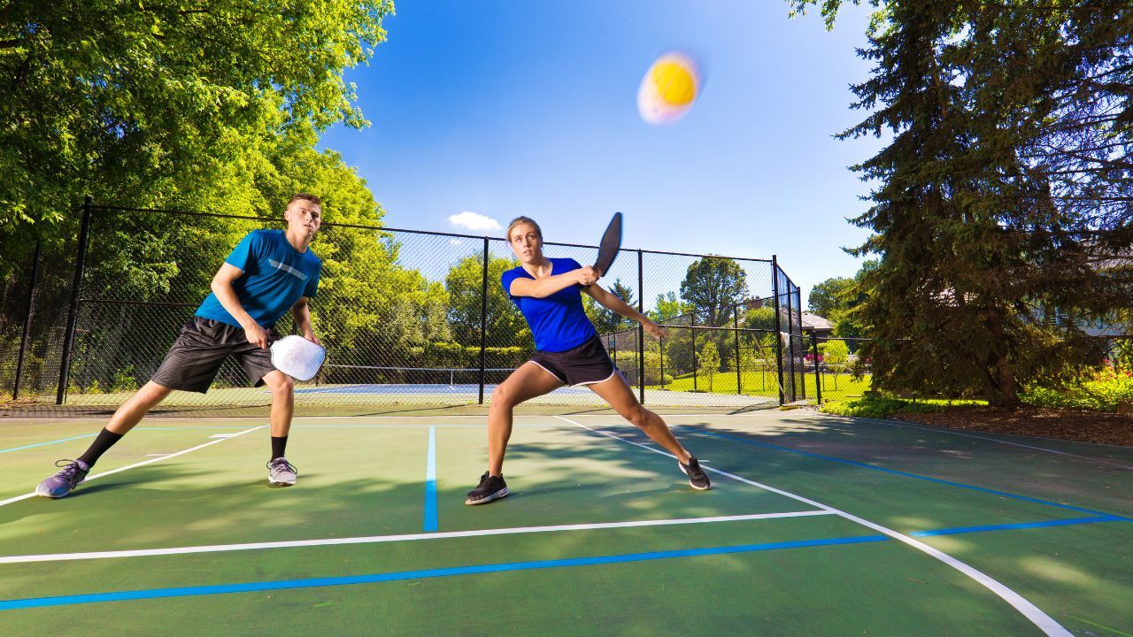 A pickleball court with two players playing the game