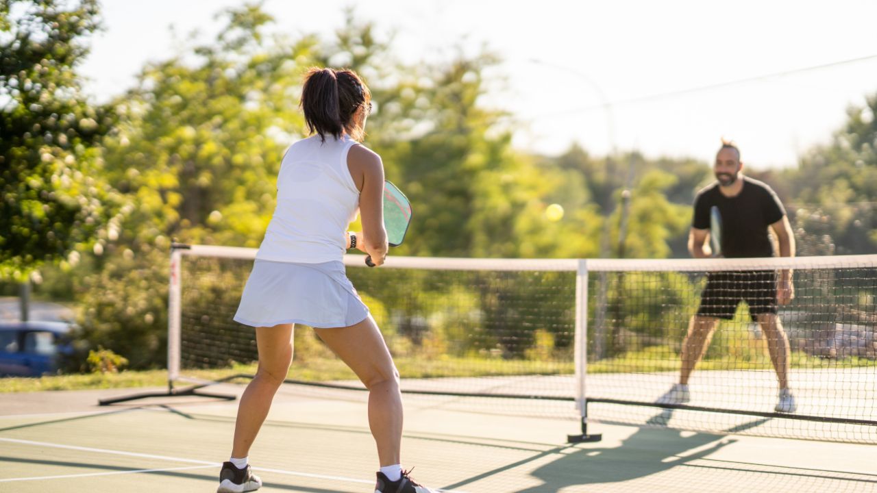 A pickleball court with two players playing the game