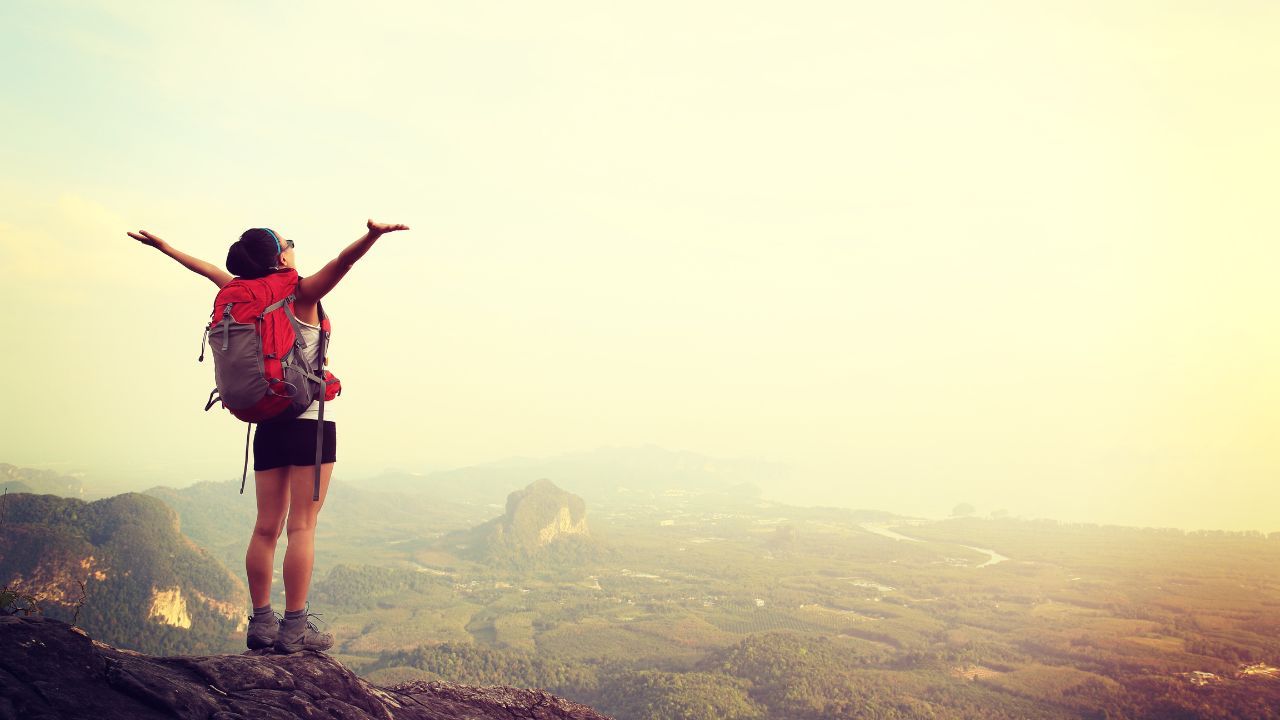 A woman wearing a hiking shirt and sports bra