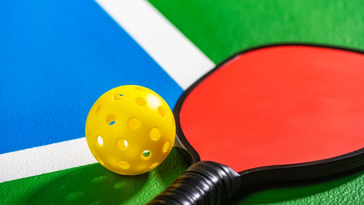 A pickleball paddle with a graphite face and a wooden core