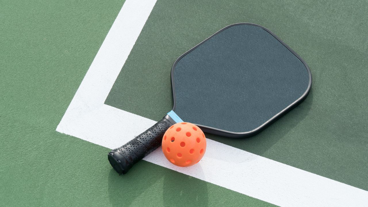 A pickleball paddle with an elongated shape and an edge guard