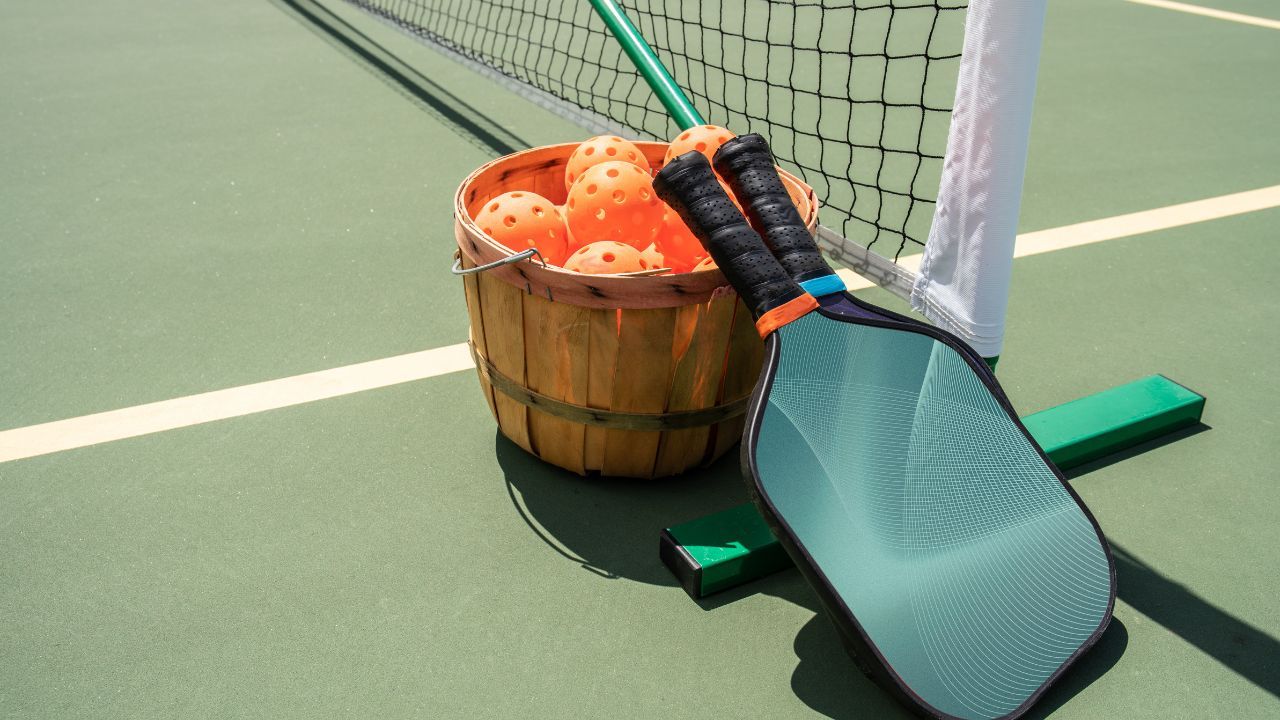 A pickleball paddle with a graphite face and a wooden core