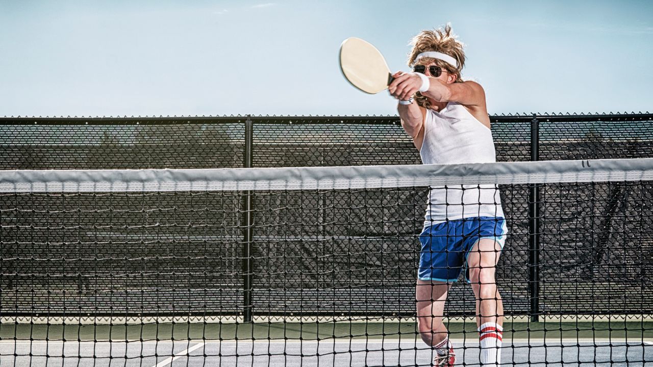 Pickleball player swinging a pickleball paddle