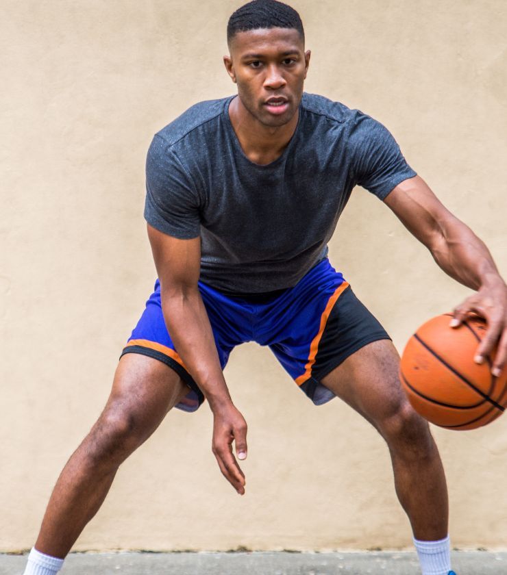 A person doing a complex training routine with a basketball in their hands.